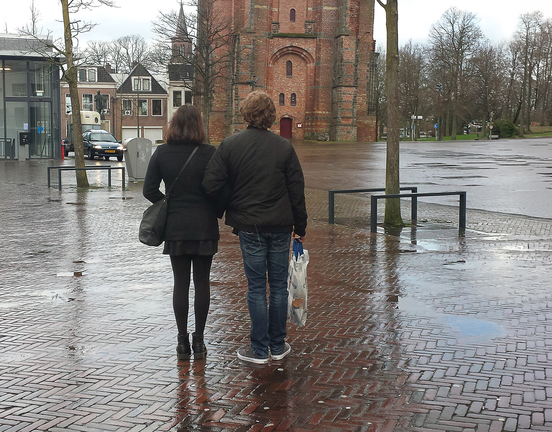 Twee mensen lopen samen over een plein